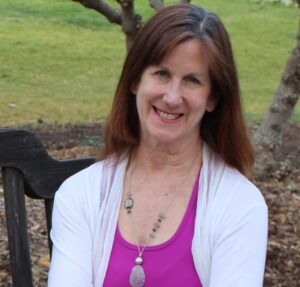 Labyrinth walking meditation teacher, Peggy Burt, seated outside.