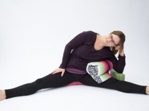 Addie deHilster doing Lateral Dragonfly Pose with Yin Yoga props