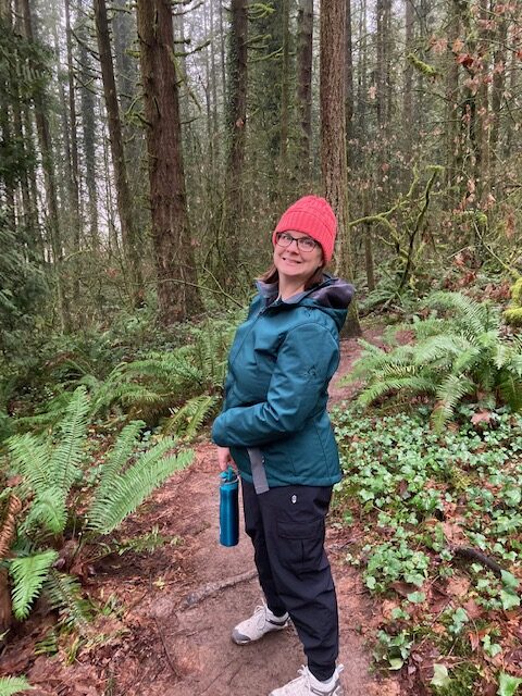 Addie deHilster smiling on a hiking trail where she practices mindful movement.