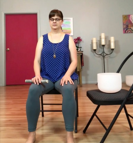 Addie deHilster sitting in a chair for movement-based mindfulness practice.