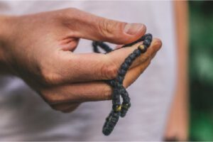 Hand holding mala beads as a tool for adhd and mindfulness meditation practice.