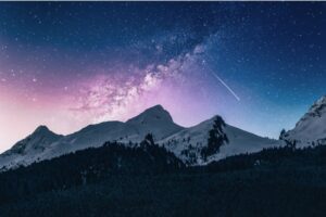 Image of starry skies over a mountain representing this breath meditation for sleep.