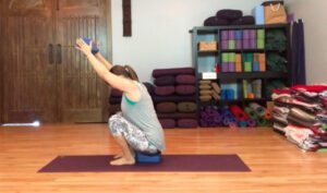 Addie deHilster in a squat pose demonstrating a mindful approach to alignment in yoga.