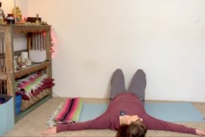 Addie deHilster lying on the floor demonstrating a somatic movement.