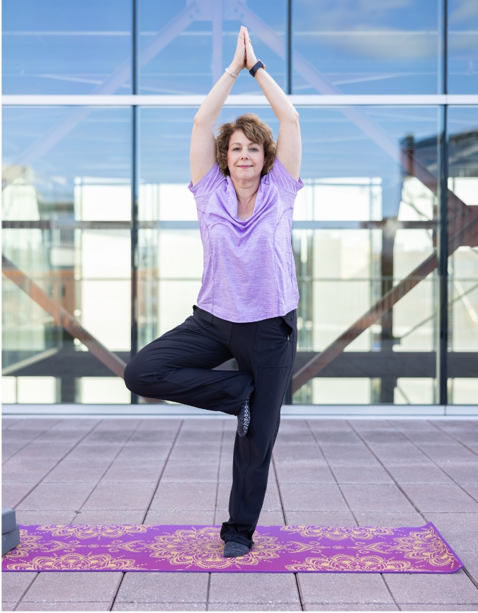 Therapist Chris McDonald doing Tree Pose as a speaker on yoga for mental health.